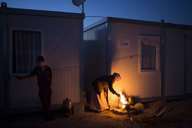 Elektirik olmadığından dolayı yemekler konteynerların kenarında kurulan ateşler üzerinde saatlerce pişirilmeye çalışıyor. Fotoğraf: Yasin Akgül